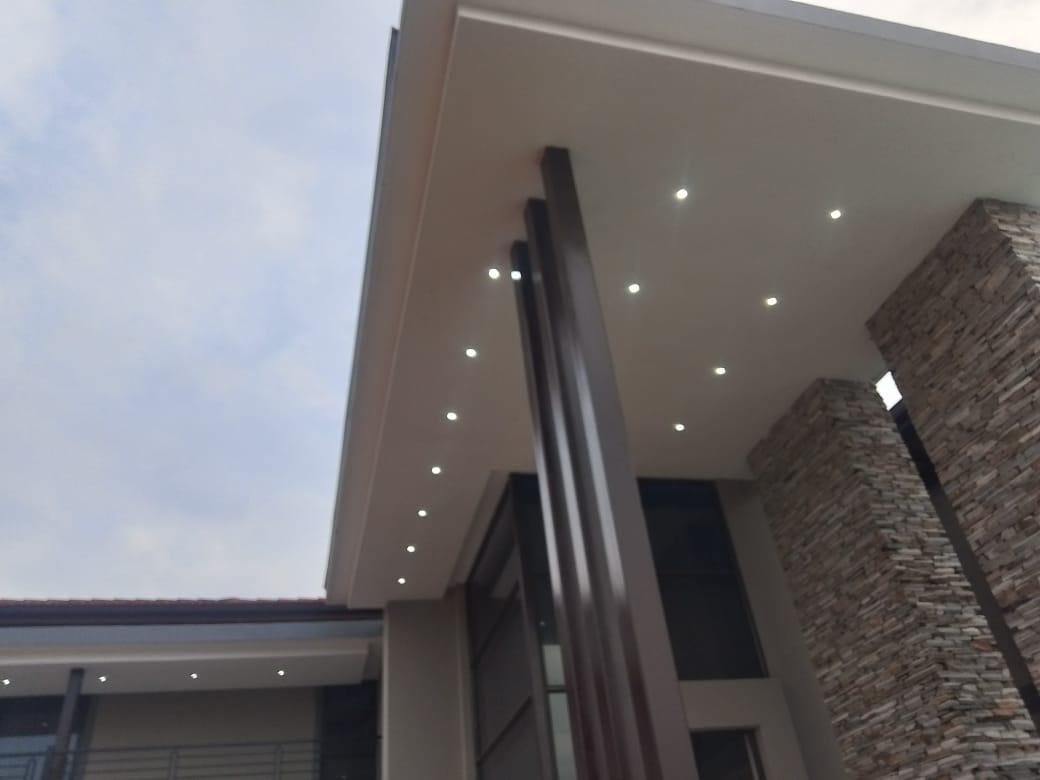Building exterior with recessed ceiling lights and stone wall