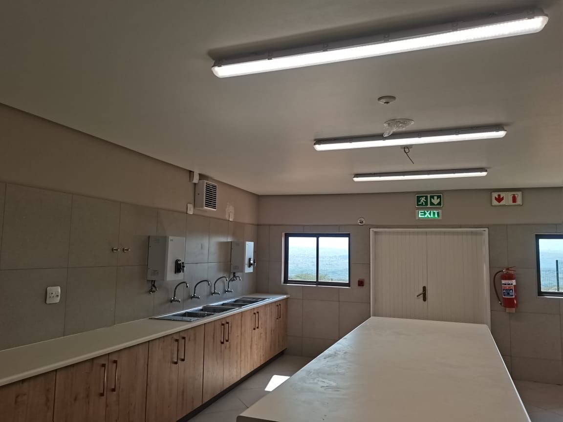 Commercial kitchen with fluorescent lights and sinks