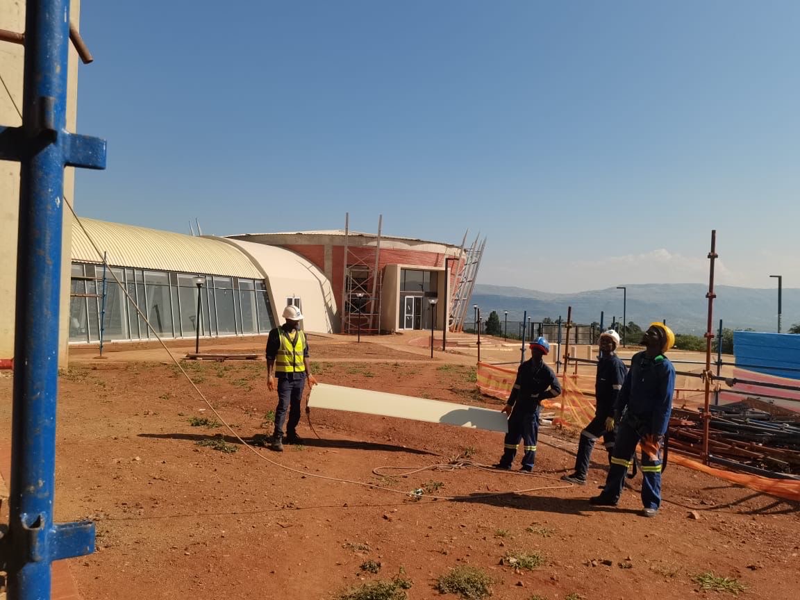 Construction site exterior with curved roof building and workers
