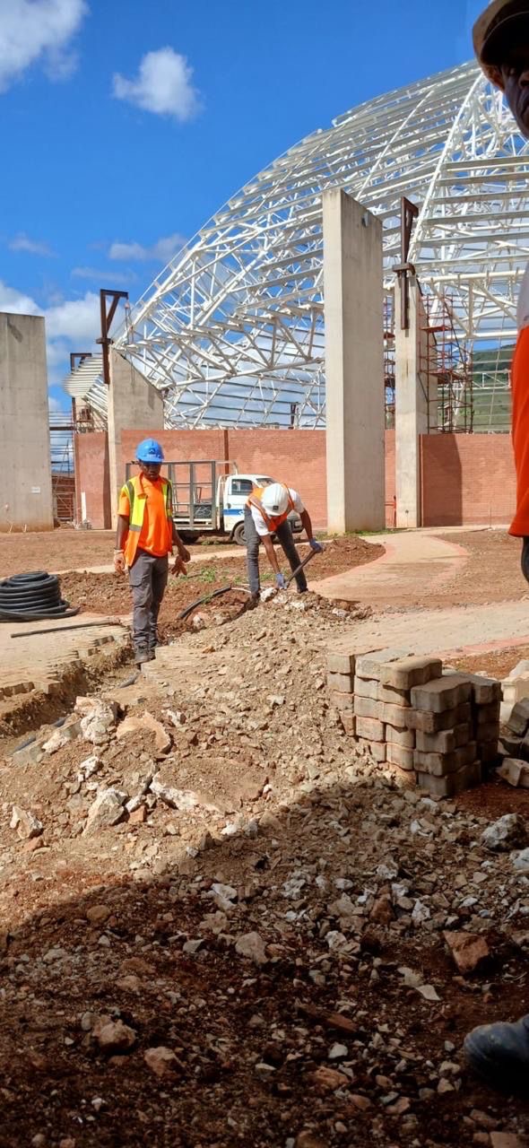 Workers at construction site with dome steel structure