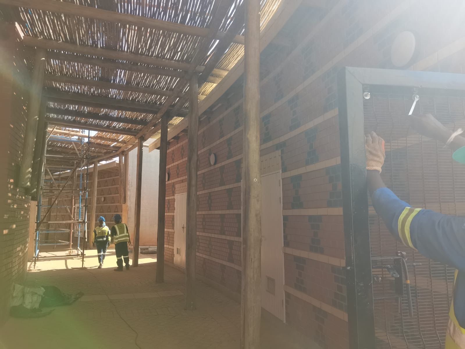Workers in walkway with decorative brickwork
