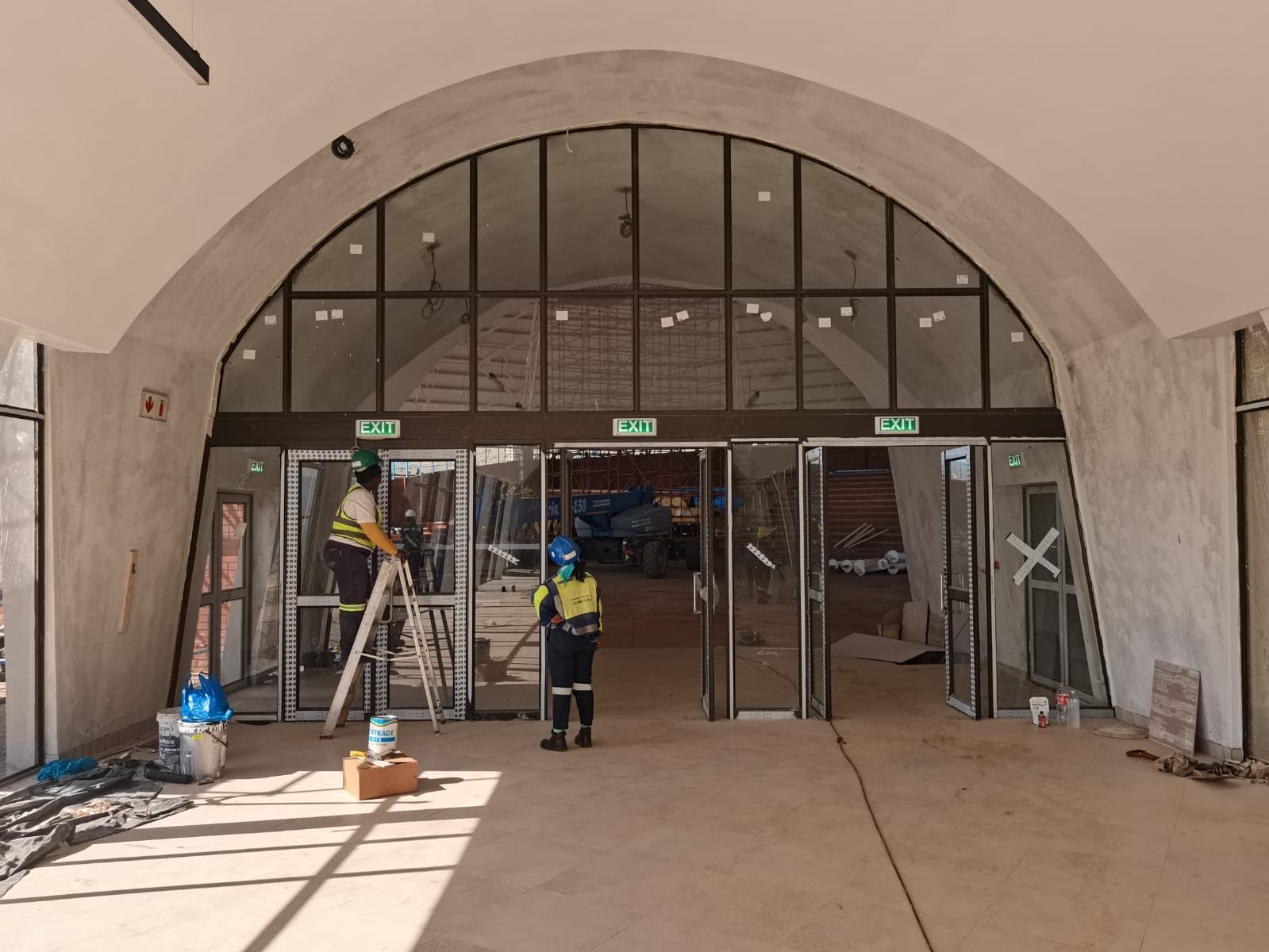Workers at arched entrance with glass doors