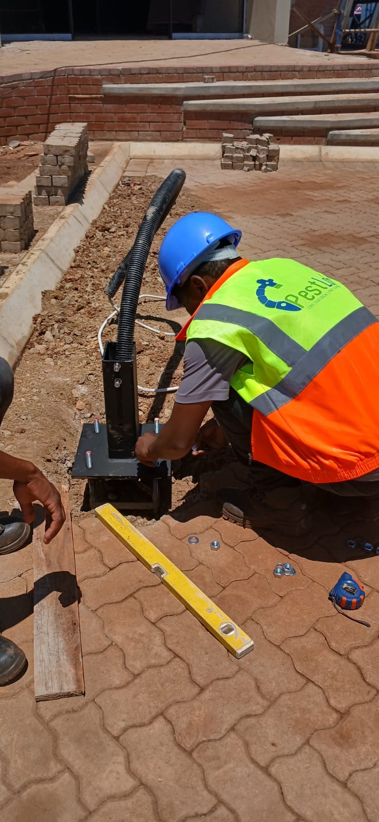 Pest Lab CC technician installing light pole base