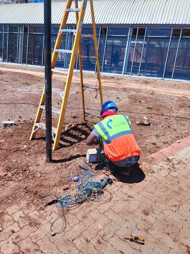 Worker at light pole base with wiring
