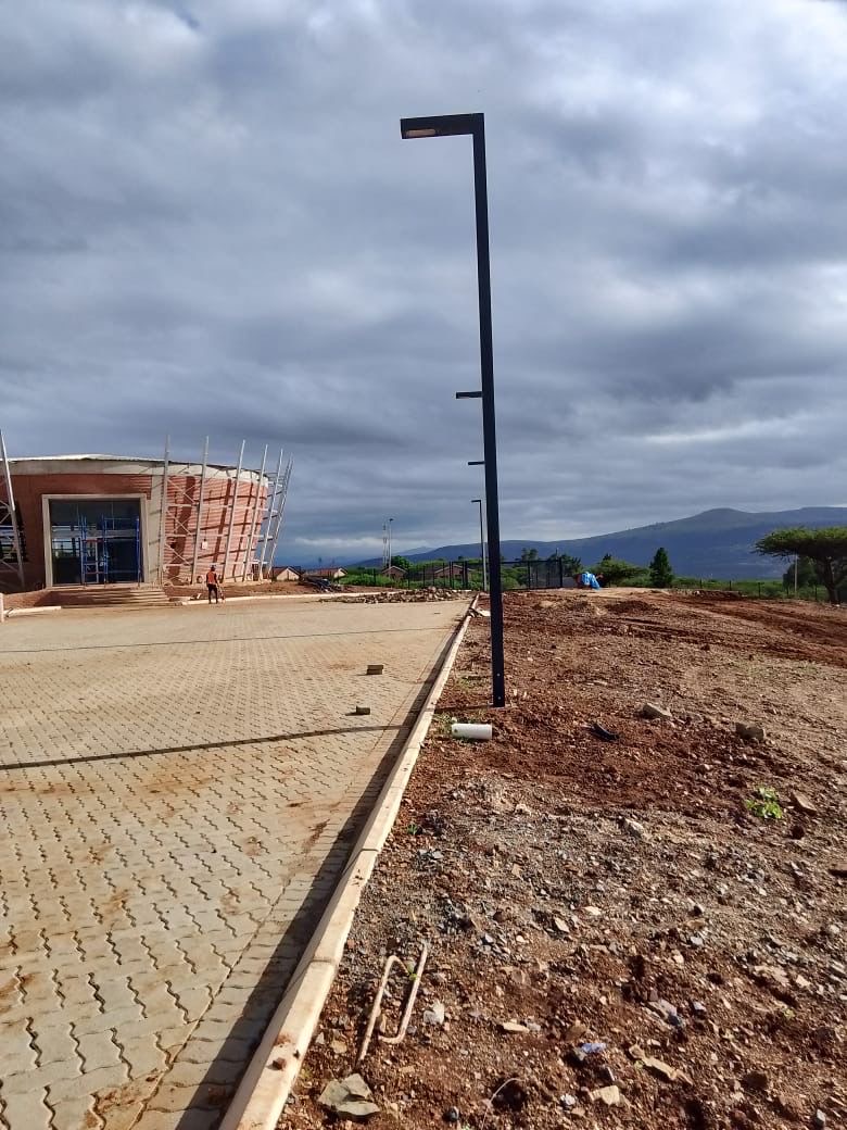 Light pole along paved road with mountain backdrop