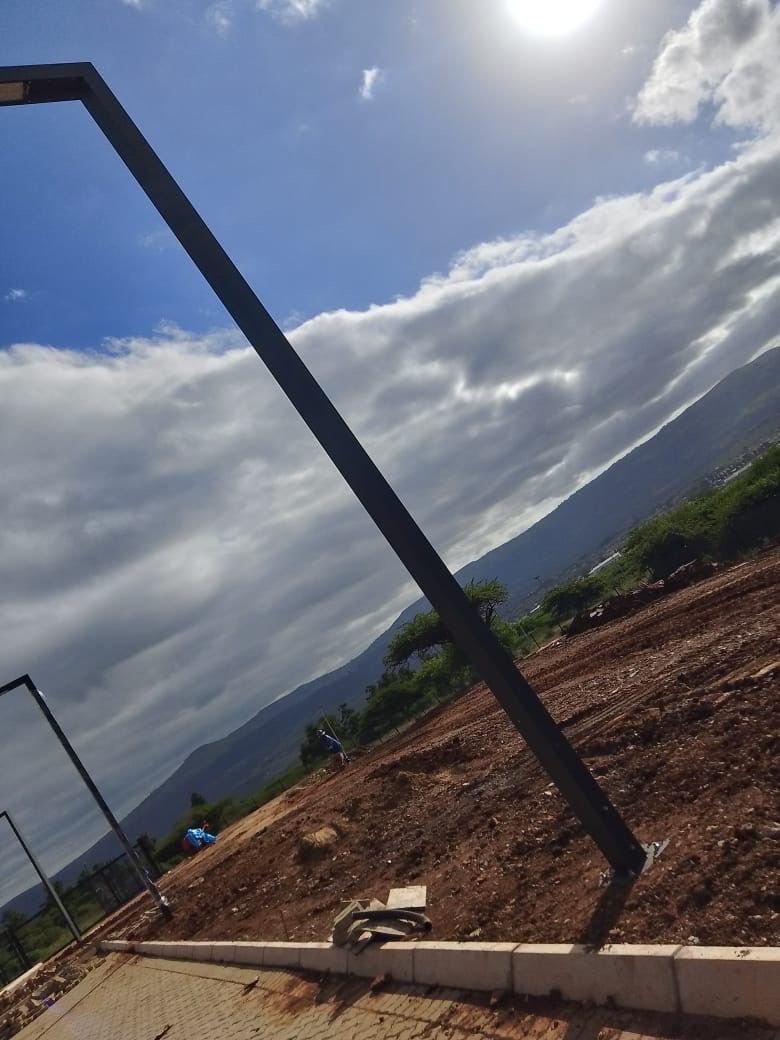 Light pole silhouette against sky with mountains