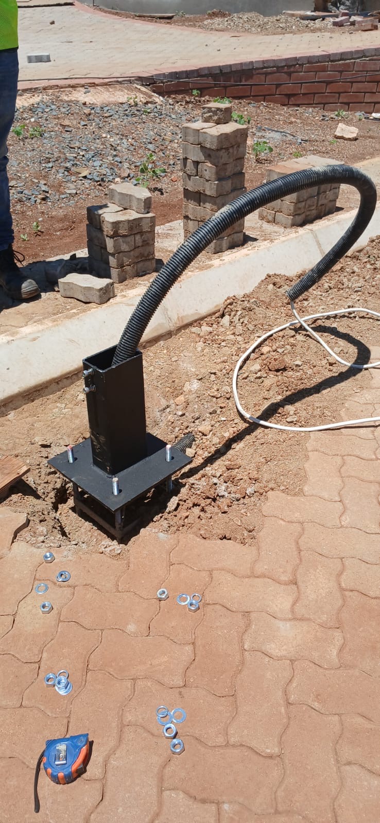Light pole base with conduit installation on paving
