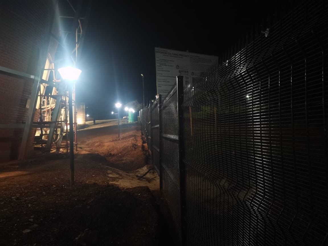 Night security lighting along fence at facility