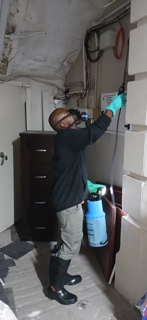 Technician spraying in tight space with respirator
